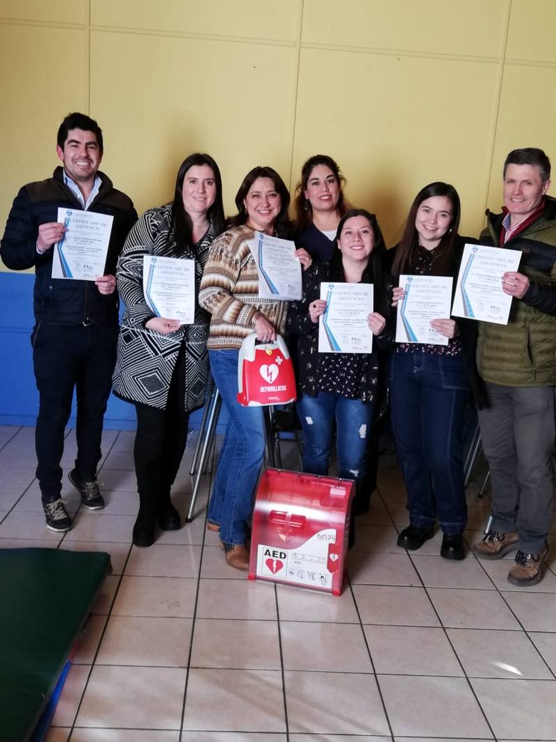 Participantes mostrando sus certificados de aprobación junto al kit de cardioprotección
