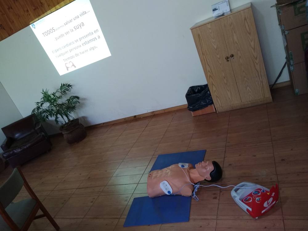 Maniquí de entrenamiento con parches de un desfibrilador externo automático conectados, durante una capacitación