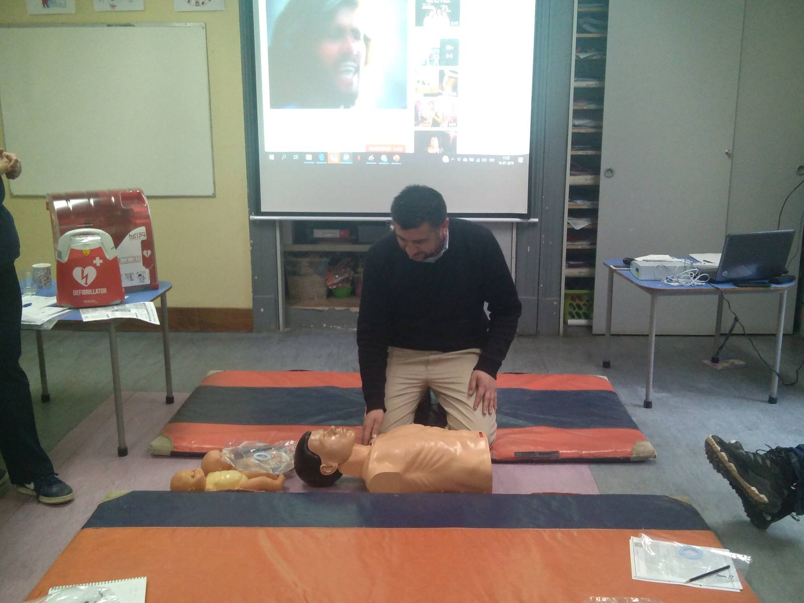 Instructor de Trainer Chile realizando compresiones torácicas sobre un maniquí durante una capacitación en un colegio